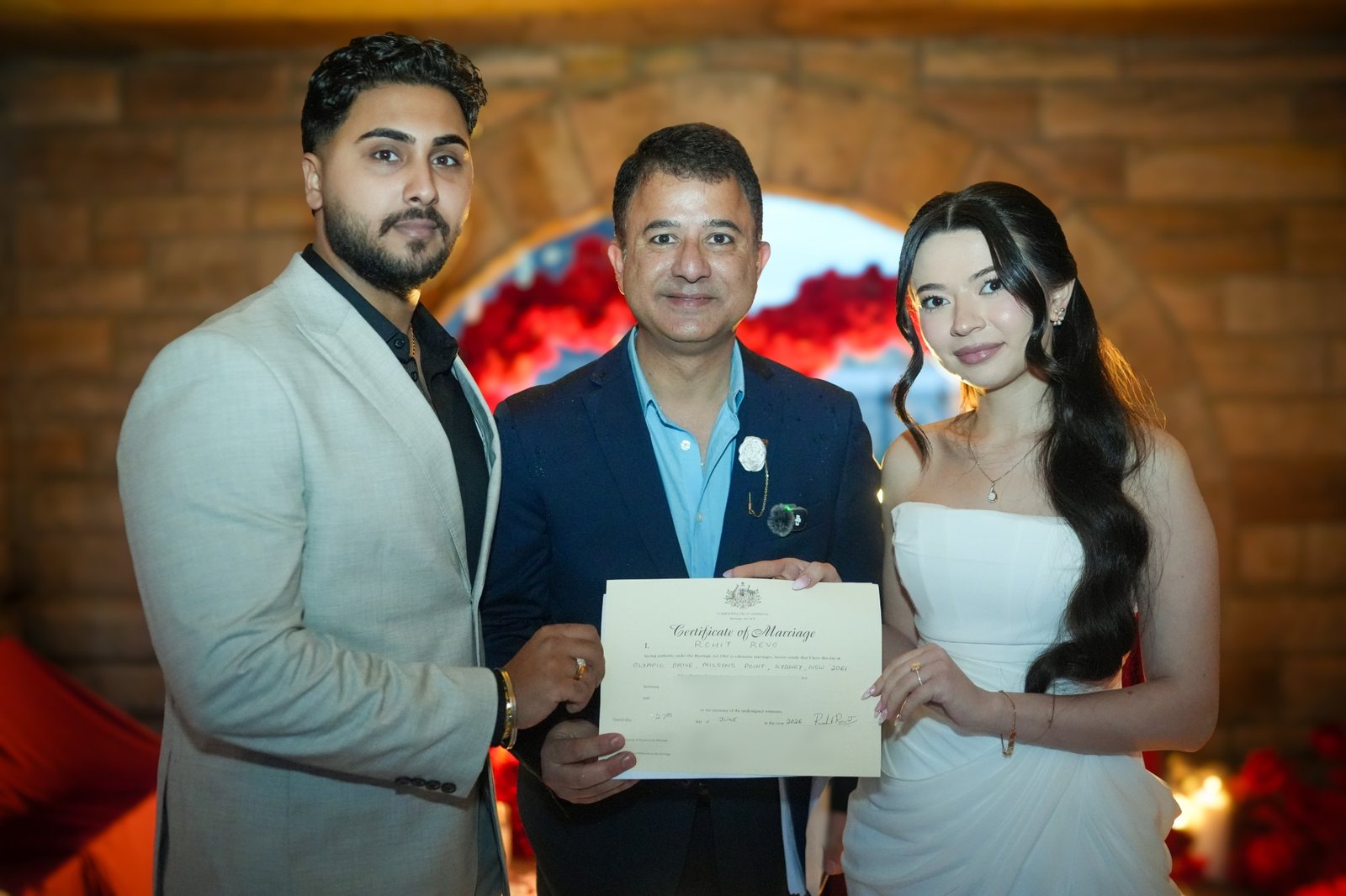 An Afghan and Punjabi couple holding their marriage certificate with their celebrant after a ceremony at Milsons Point, Sydney