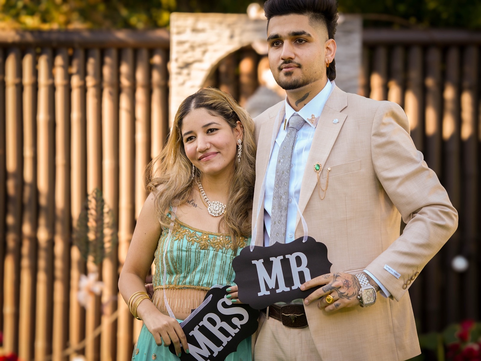 Bhavdeep and Nancy holding Mr and Mrs boards at their backyard wedding in Sydney