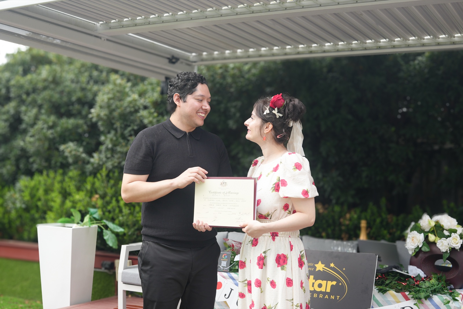 Manon and Karim holding their marriage certificate at their French–Mexican garden wedding in Sydney