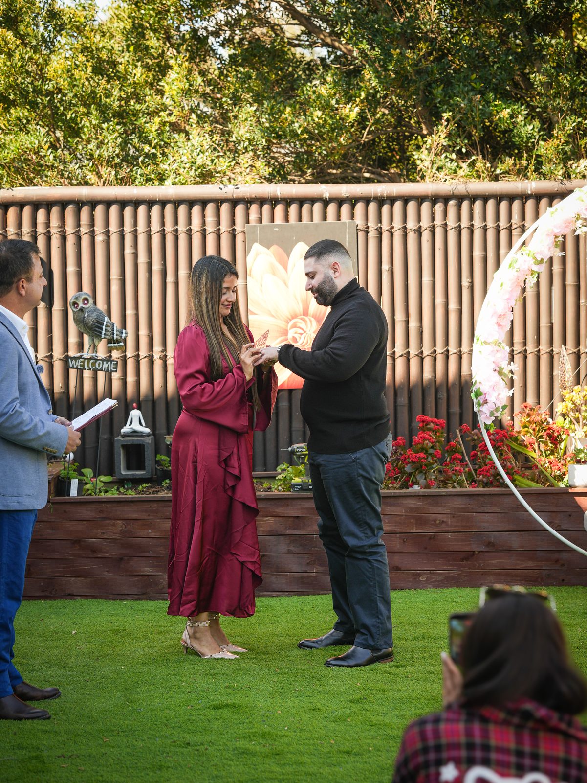 Ring being placed on the bride's finger during an intimate cross-cultural garden wedding ceremony in Sydney's Hills District