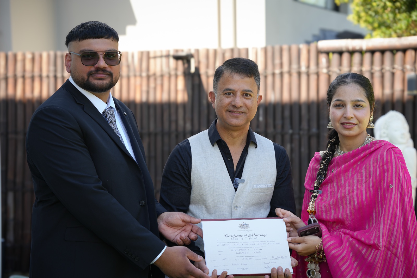 Gurpreet and Harpreet holding their marriage certificate with their celebrant at their backyard wedding in Sydney