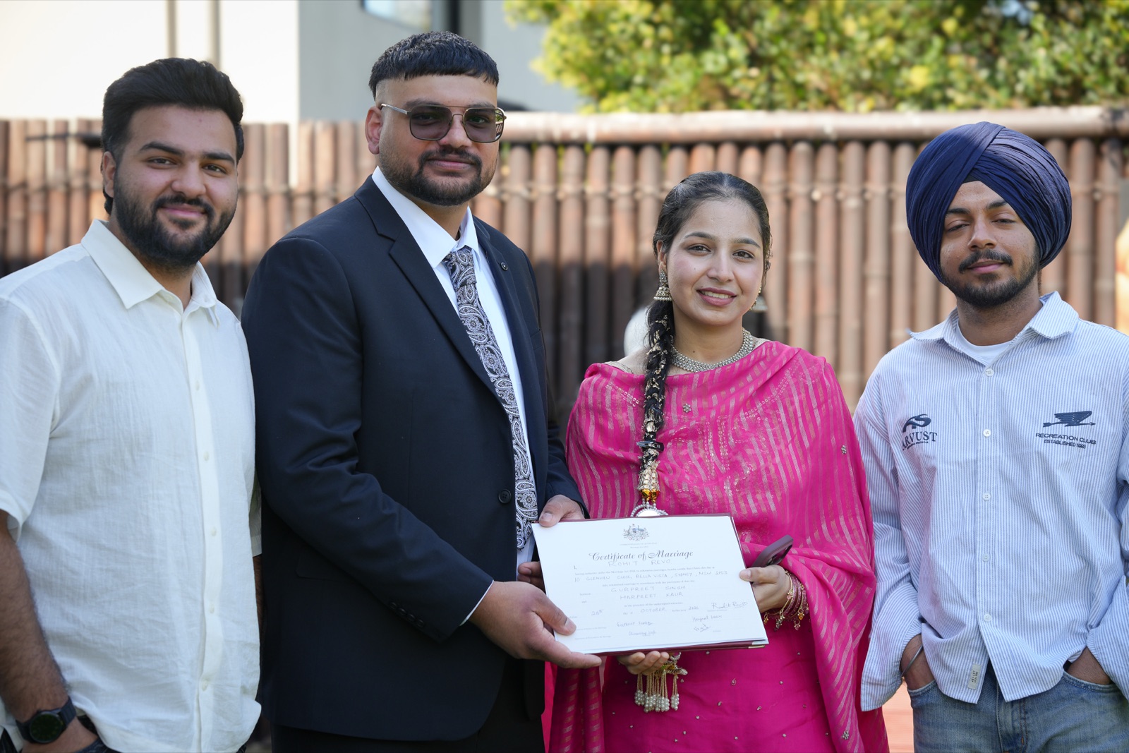 Gurpreet and Harpreet with two guests, holding their marriage certificate after their backyard wedding in Sydney