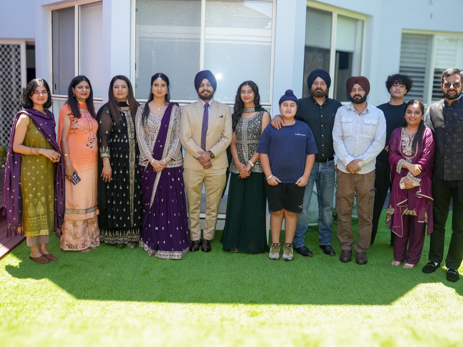 Kanwarpal and Jashandeep with relatives from both families standing together on the lawn at their garden wedding in Sydney
