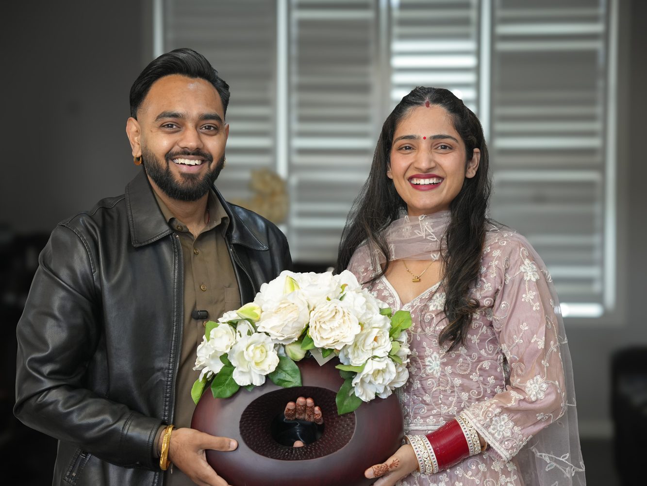 Punjabi couple Lakhwinder and Harpreet holding white florals at their intimate home wedding ceremony in Bella Vista, Sydney