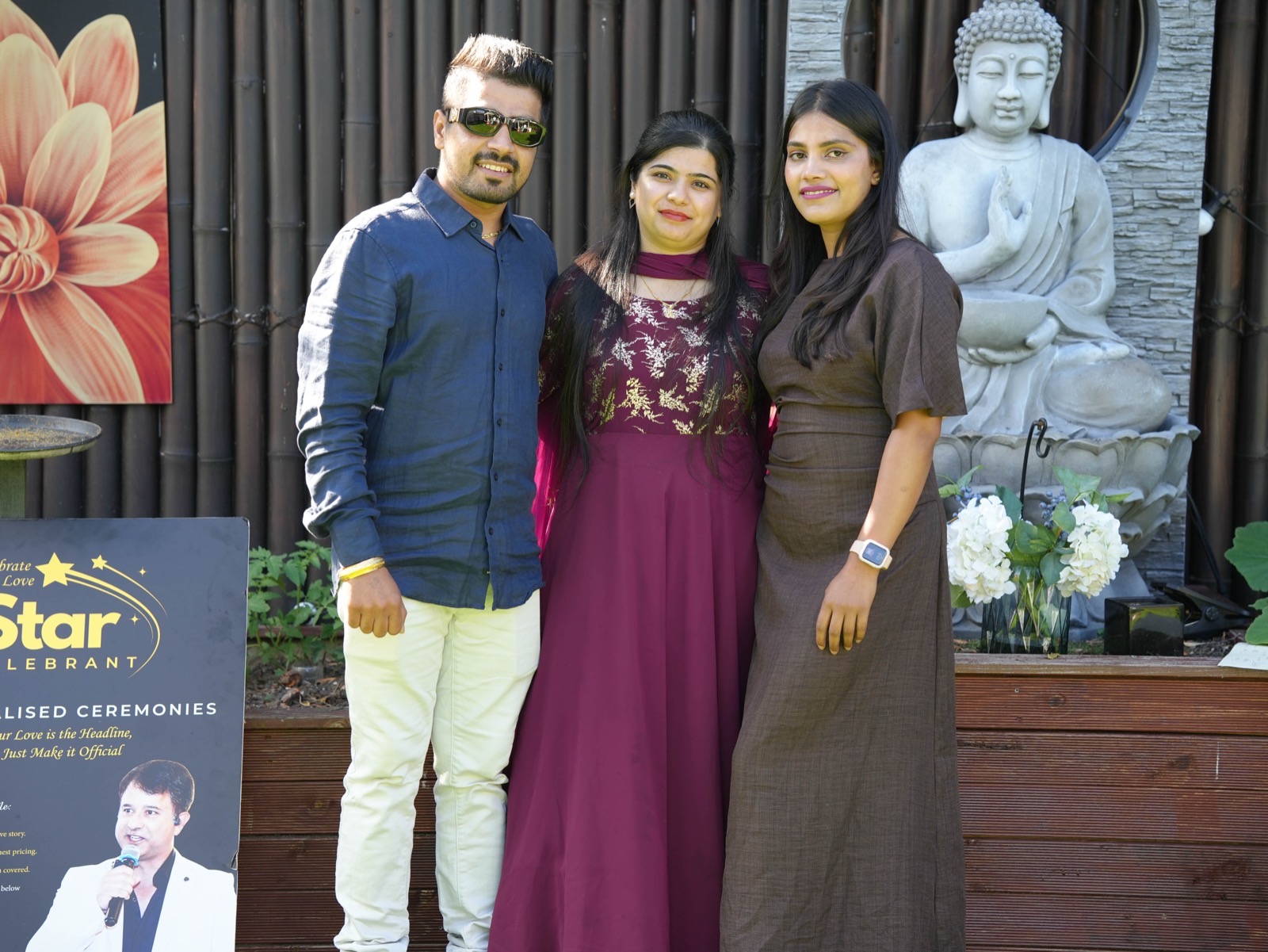 Sahil and Radhika with a loved one in front of the garden Buddha at their Sydney wedding