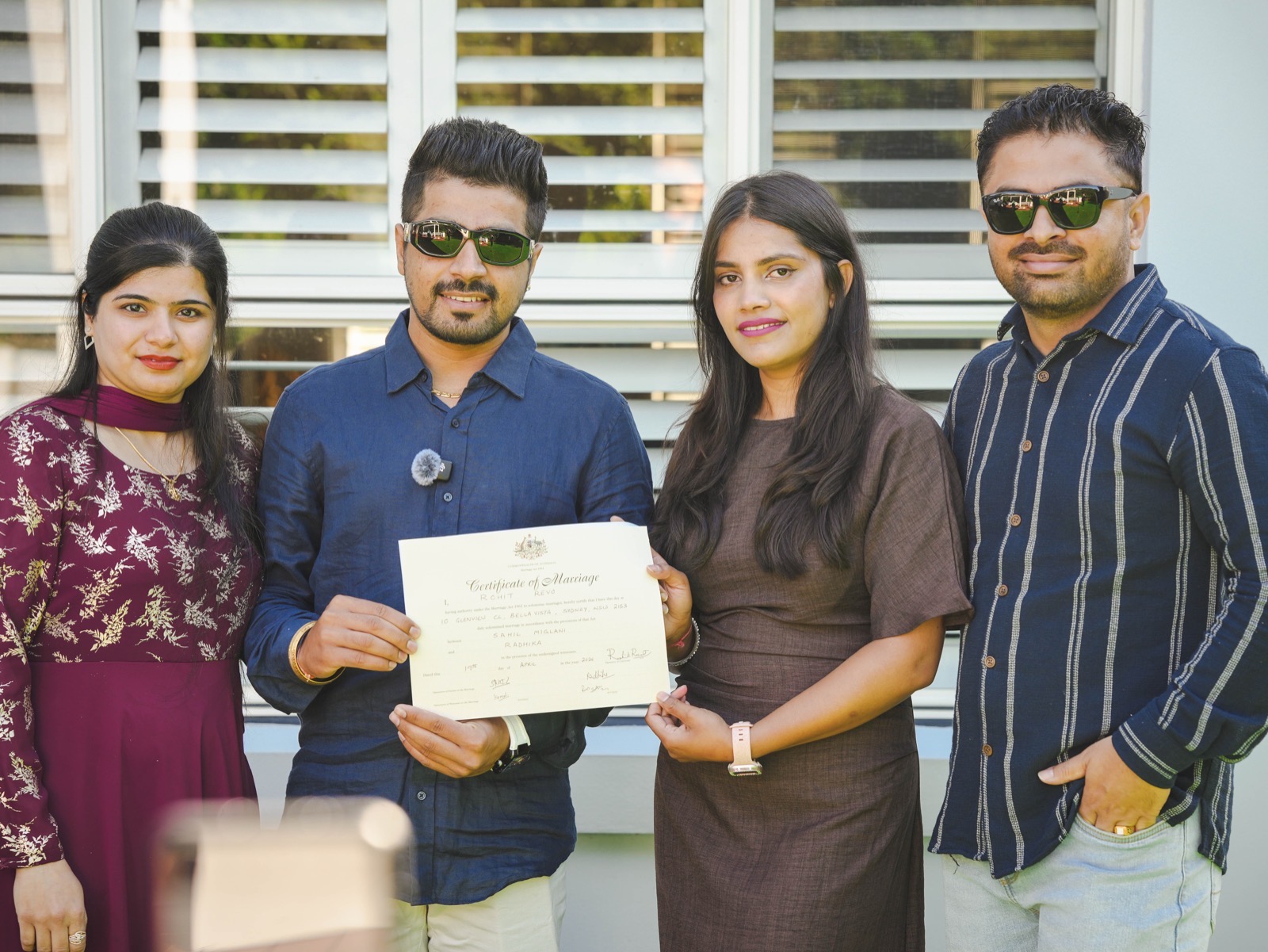 Sahil and Radhika holding their marriage certificate with their witnesses after their Sydney ceremony