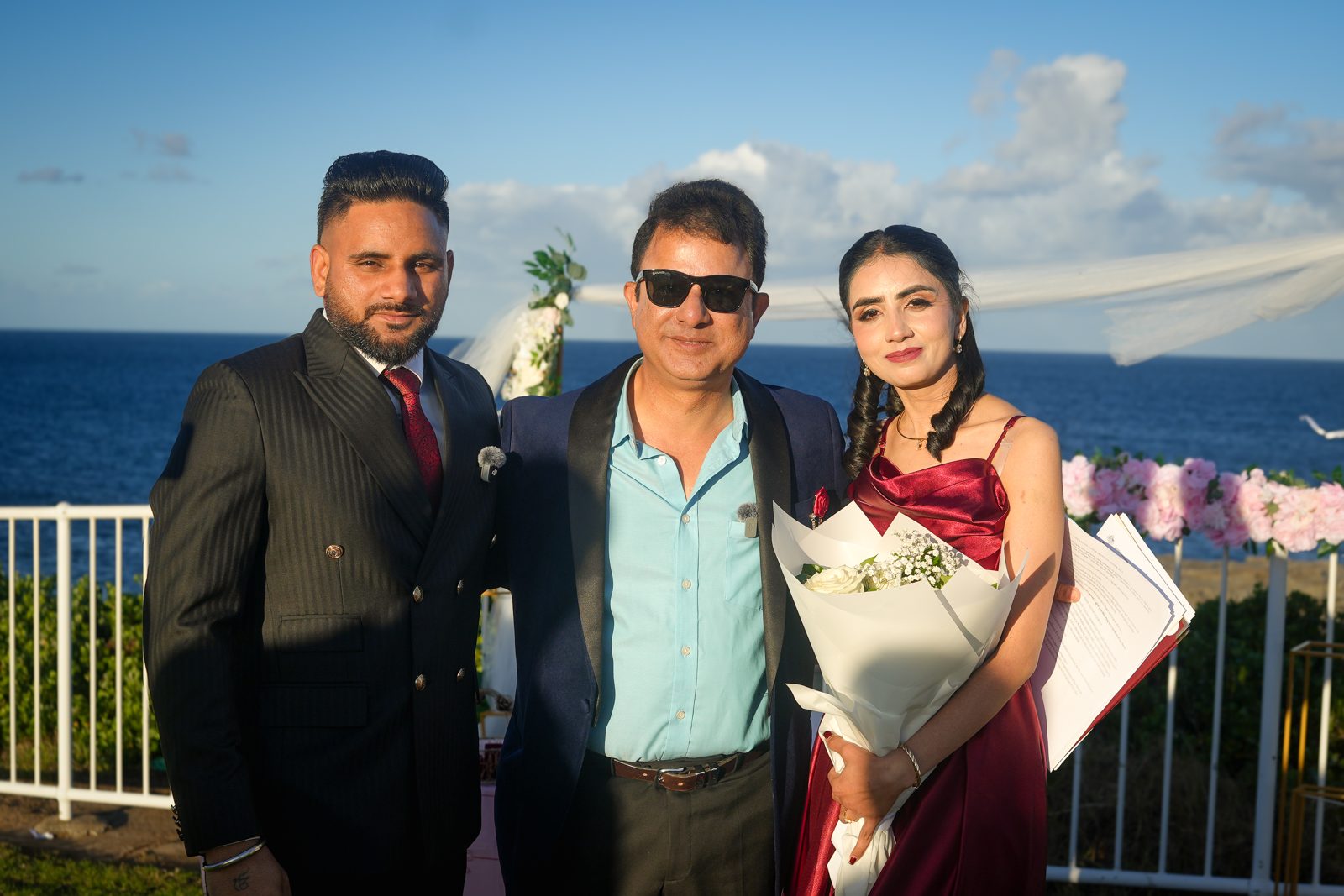 Lovepreet and Gurpinder with celebrant Rohit Revo holding her bouquet and the ceremony papers after their wedding at Wollongong lighthouse